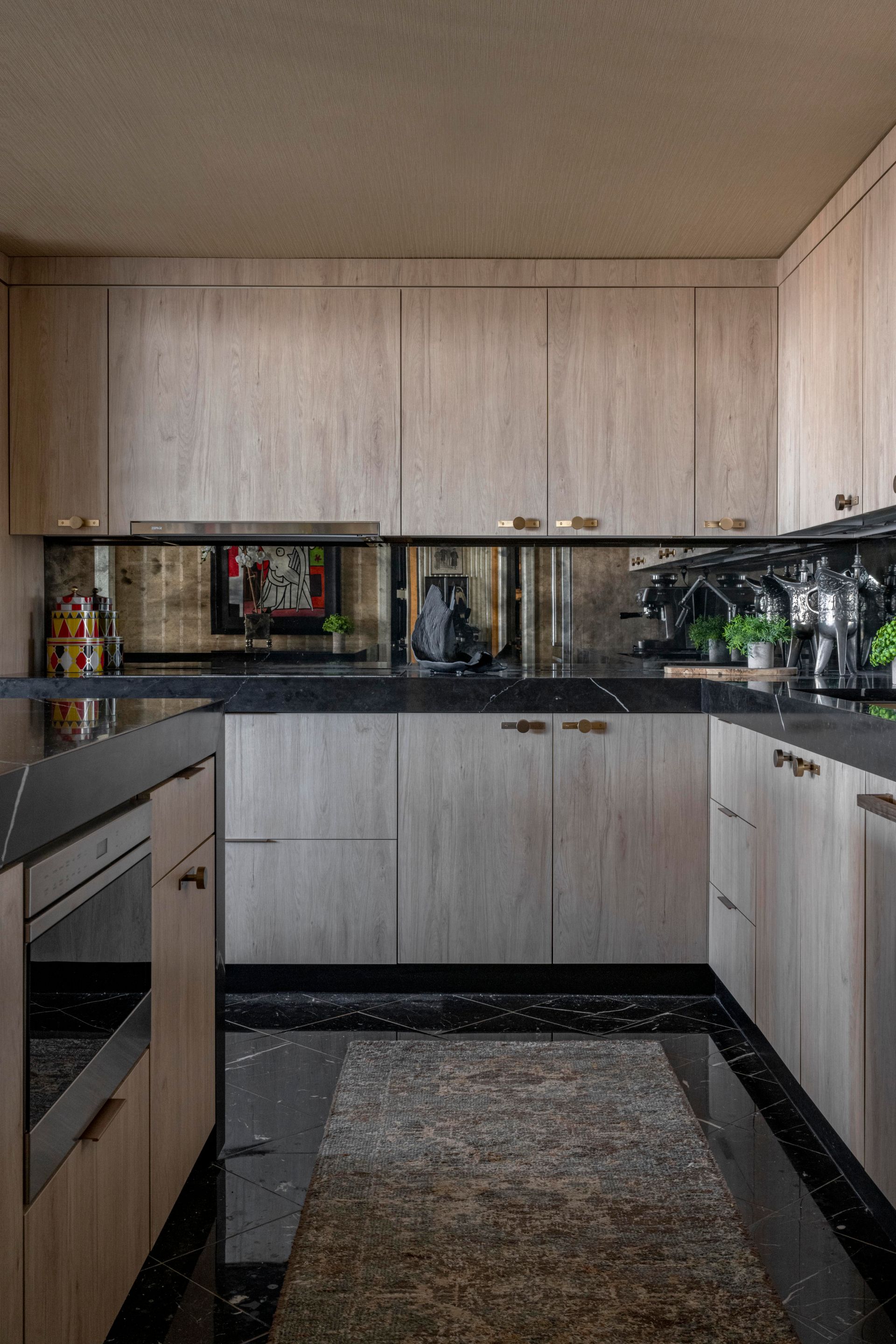 A kitchen with wooden cabinets and black counter tops.