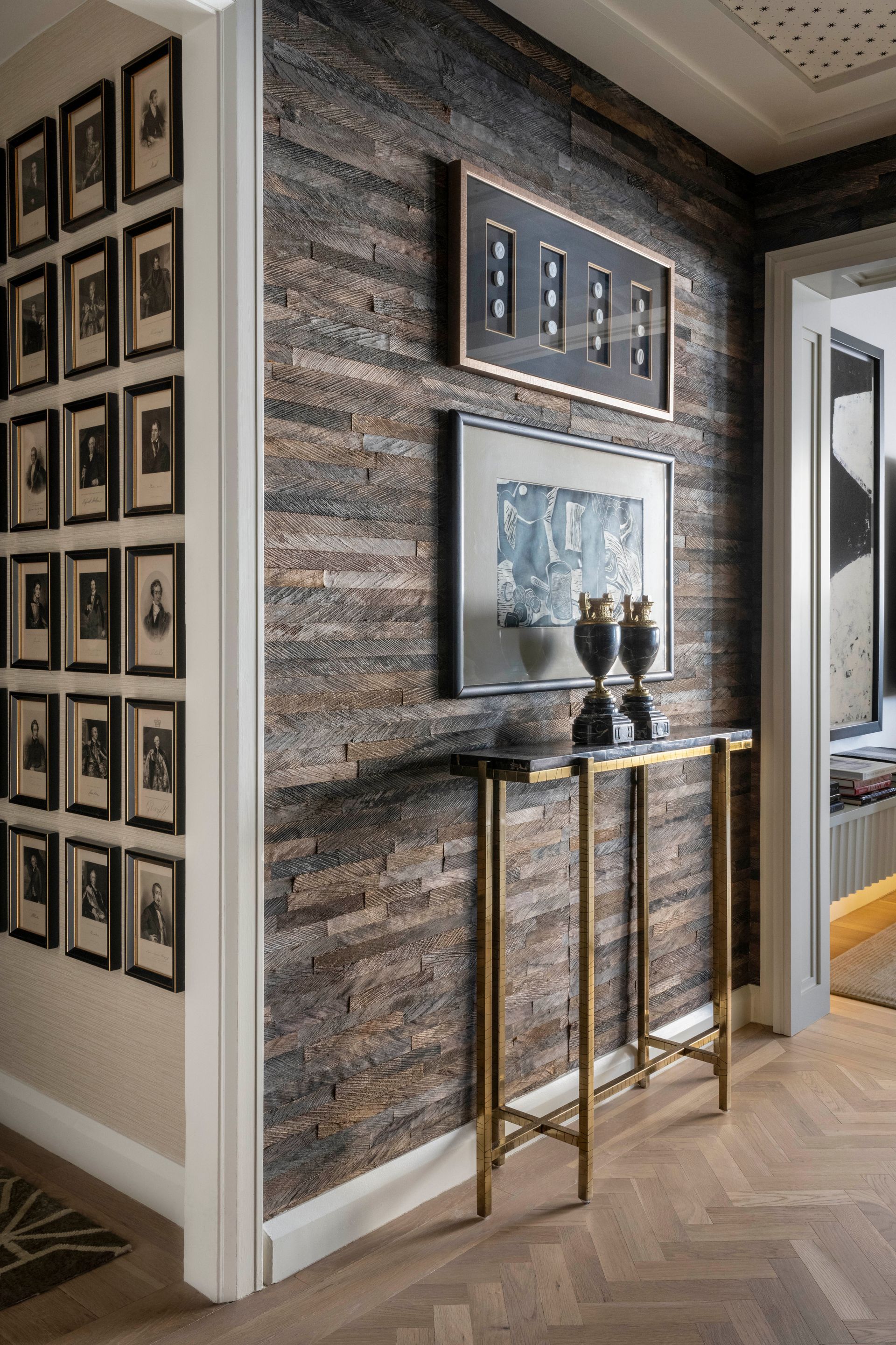 A hallway with a table and pictures on the wall.