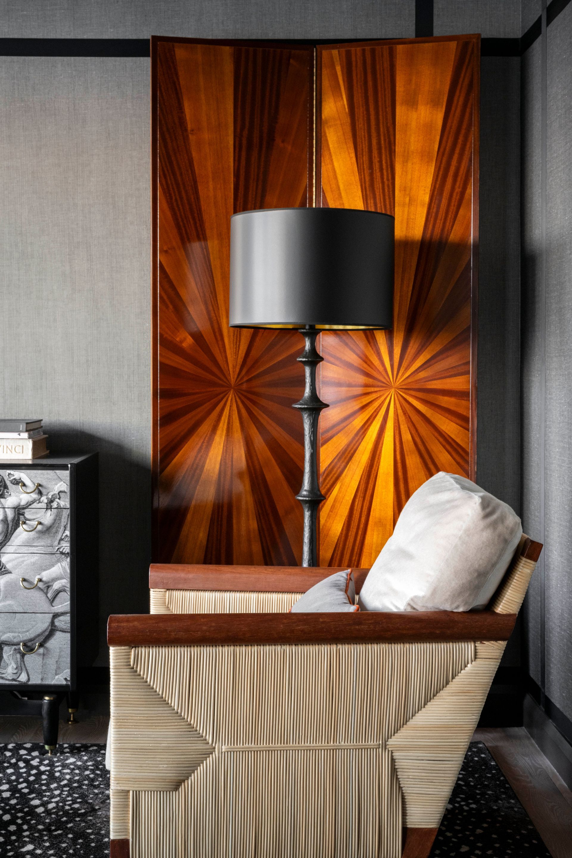 A chair and a lamp in a room with a wooden wall