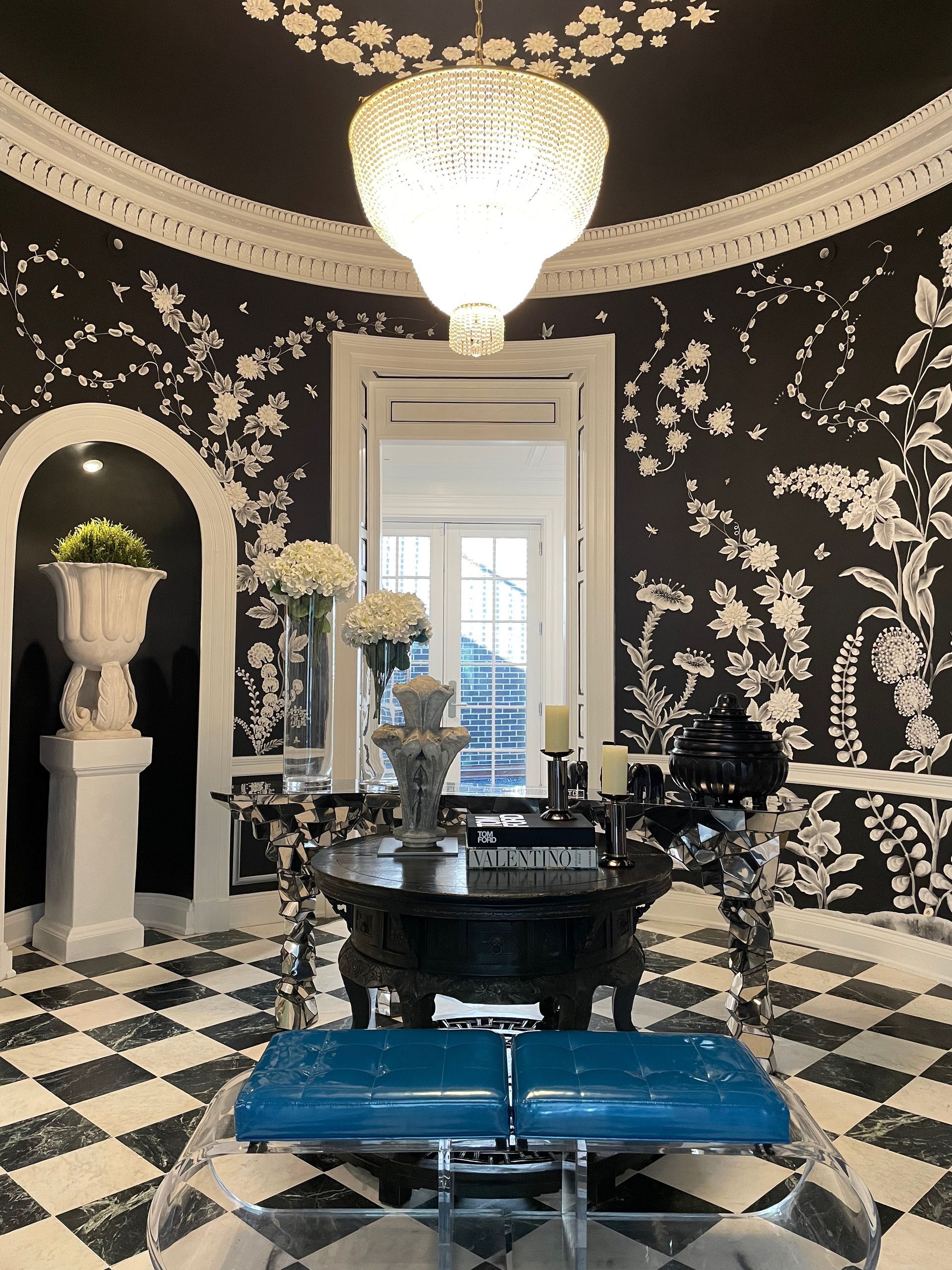 A black and white room with a checkered floor and a chandelier
