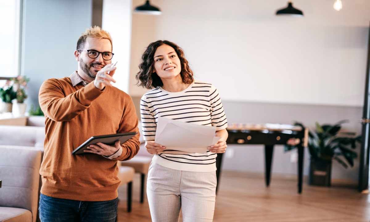 A man and a woman are standing next to each other in an office.