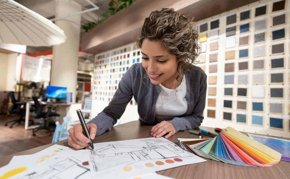 A woman is sitting at a table writing on a piece of paper.