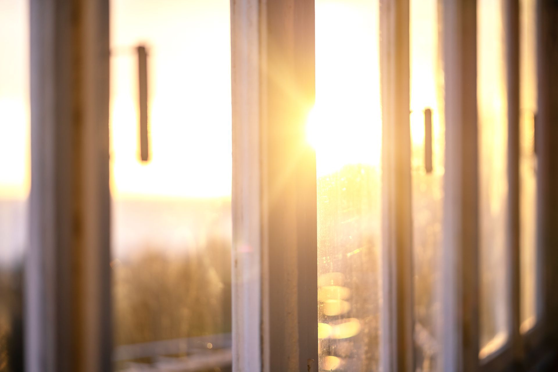 A west-facing window with bright sun streaming inside, causing heat gain without efficient window tr