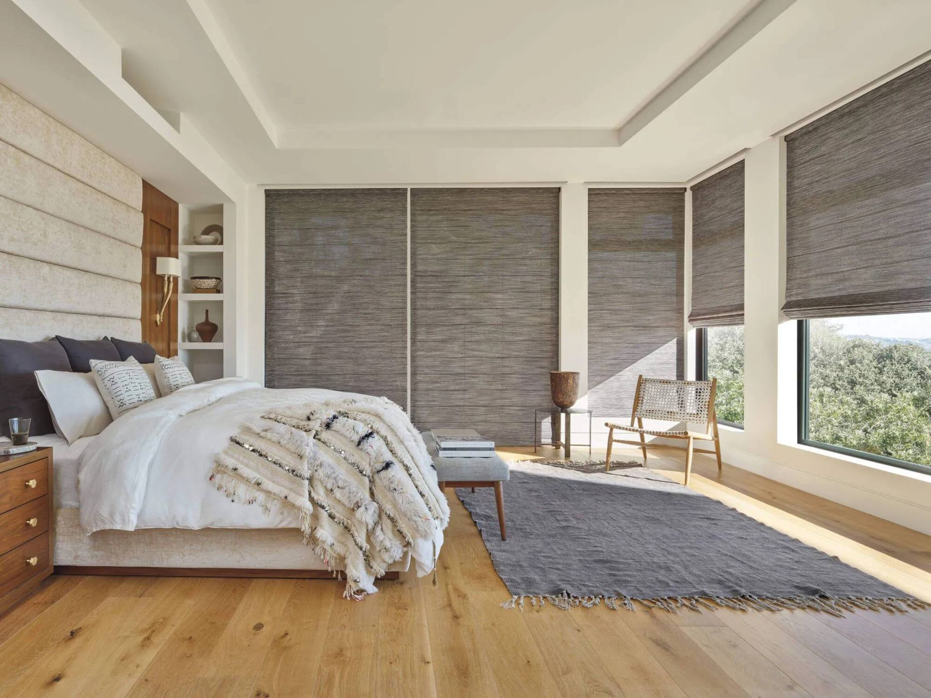 Hunter Douglas Alustra® Woven Textures® Roman Shades on several windows in a bedroom
