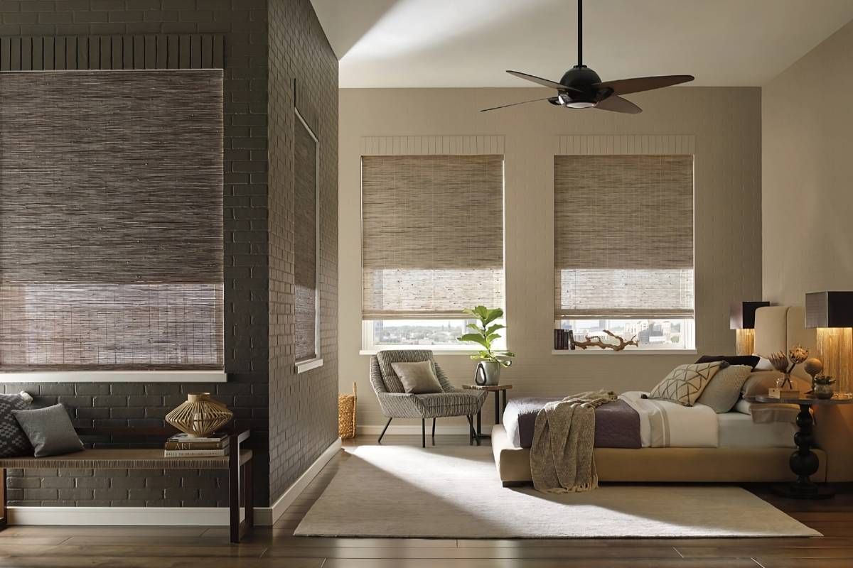 Hunter Douglas woven wood window shades on large windows in a chic and cozy bedroom at Custom Wood Shutters and Blinds near Tustin, CA