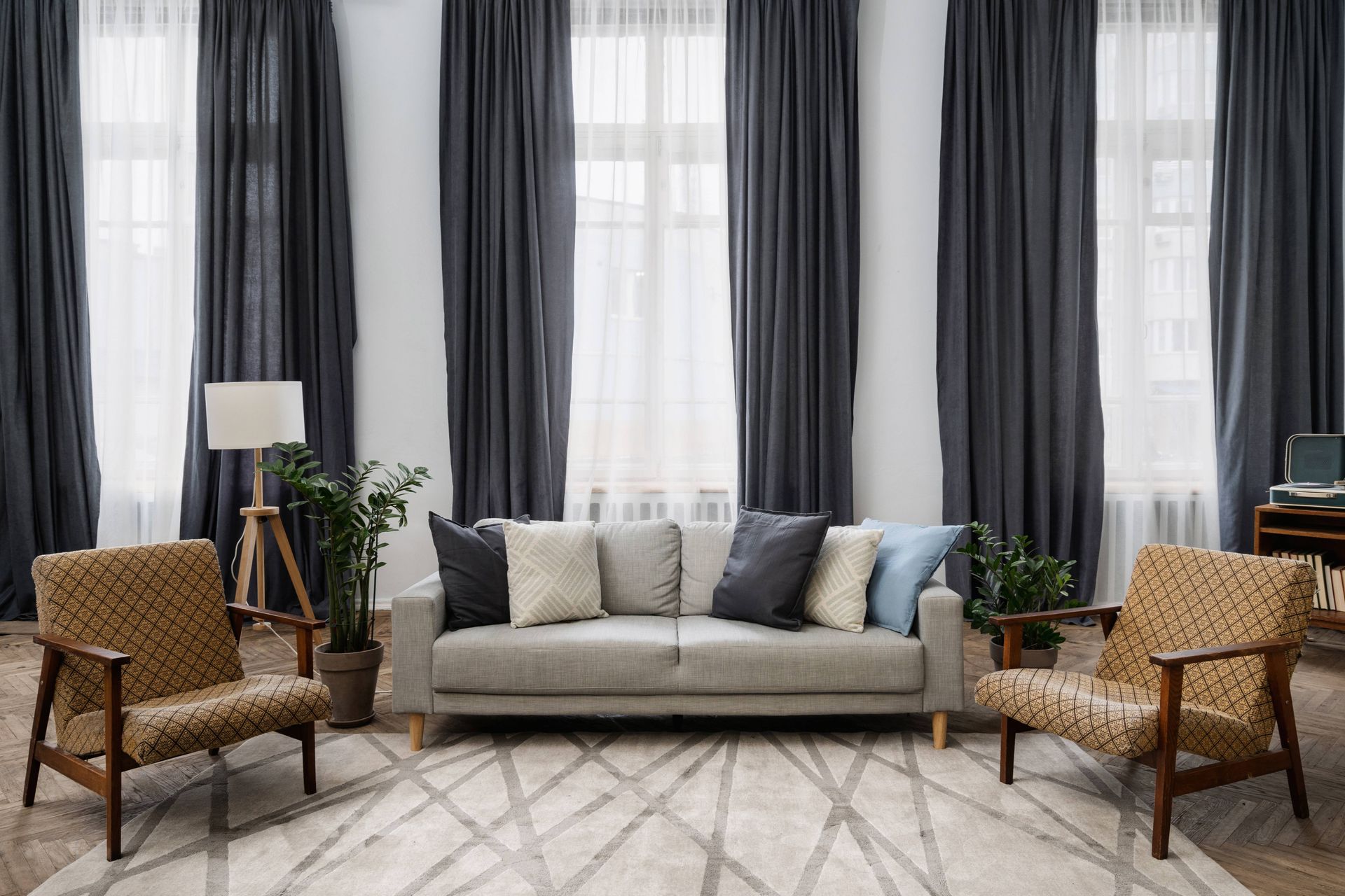 A traditional living room with north-facing windows that have sheer shades on them