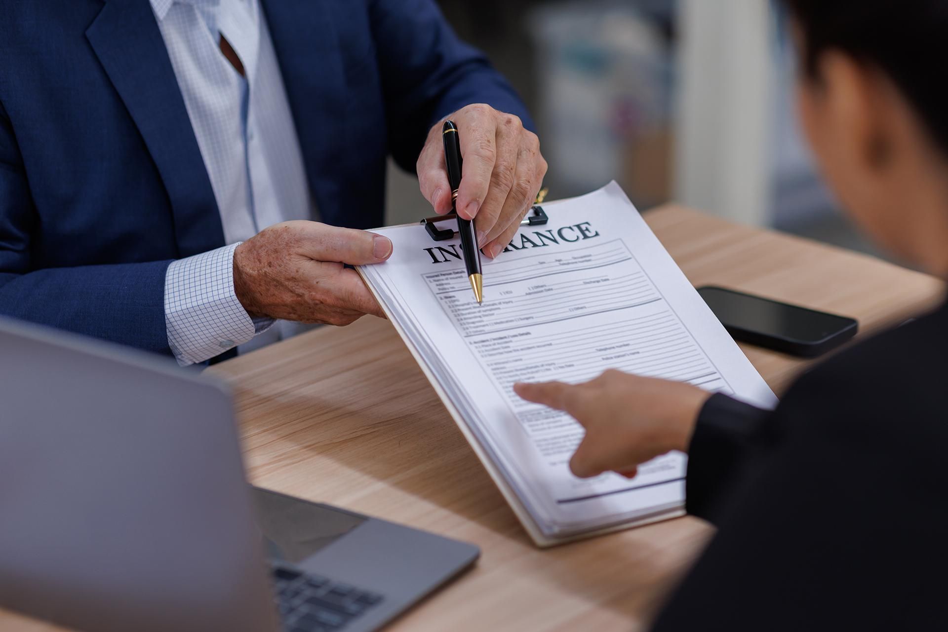Business meeting with people reviewing and signing a document at a table