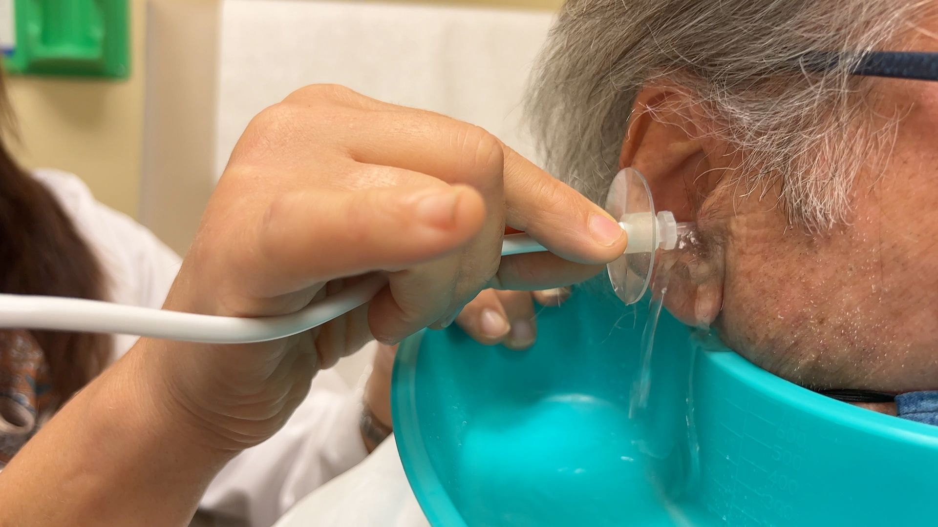 A doctor is examining a man 's ear with an otoscope
