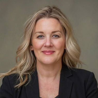 A woman in a suit is holding a tablet computer in her hands.