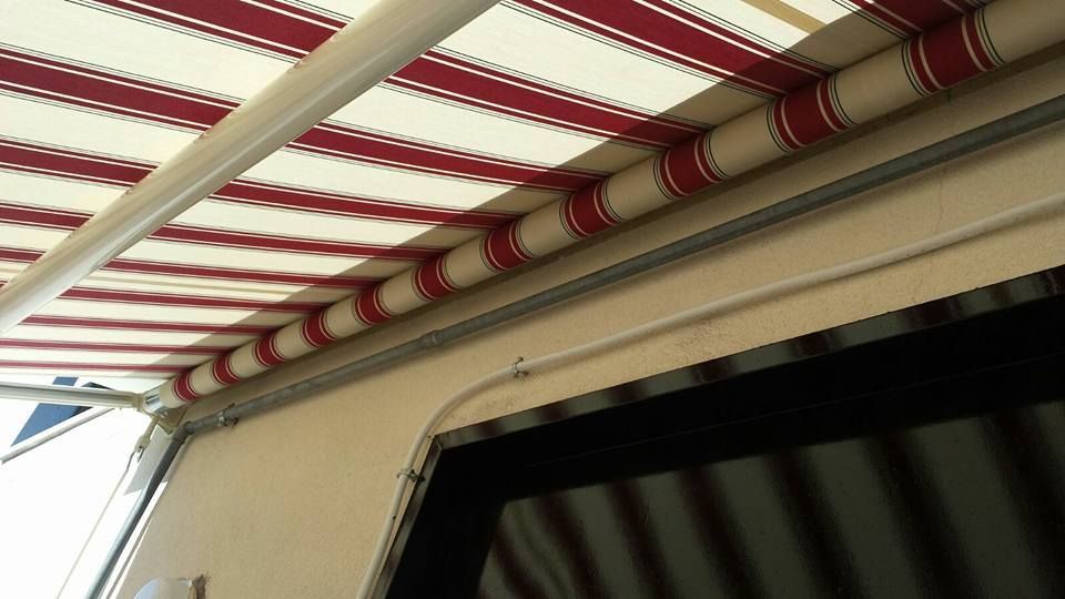 Una tenda a strisce rosse e bianche è appesa sopra una finestra