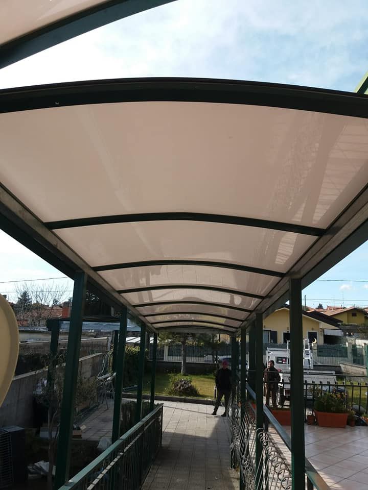 Una passerella con tetto bianco e ringhiera verde