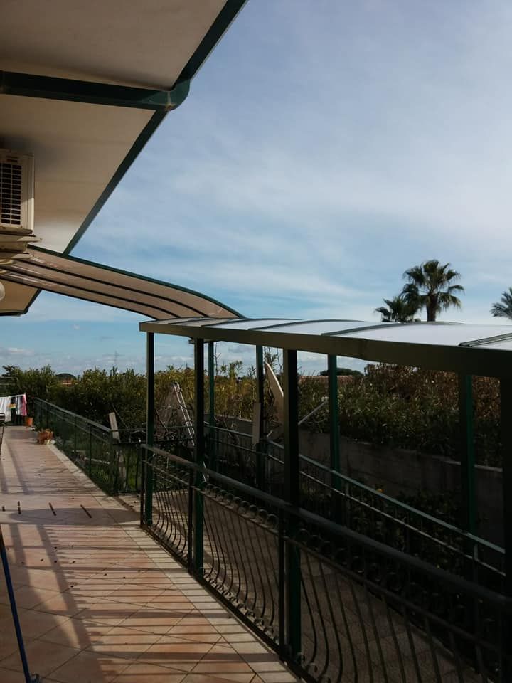 Una passerella con una tettoia e una palma sullo sfondo