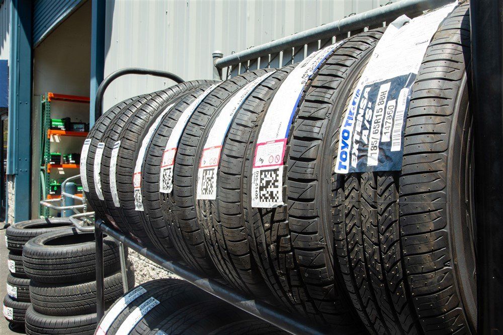 Rows of car tires displayed outside a shop, with price tags attached.