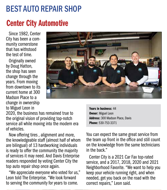 Center City Automotive ad with three mechanics standing in a garage beside a black car and shop details.