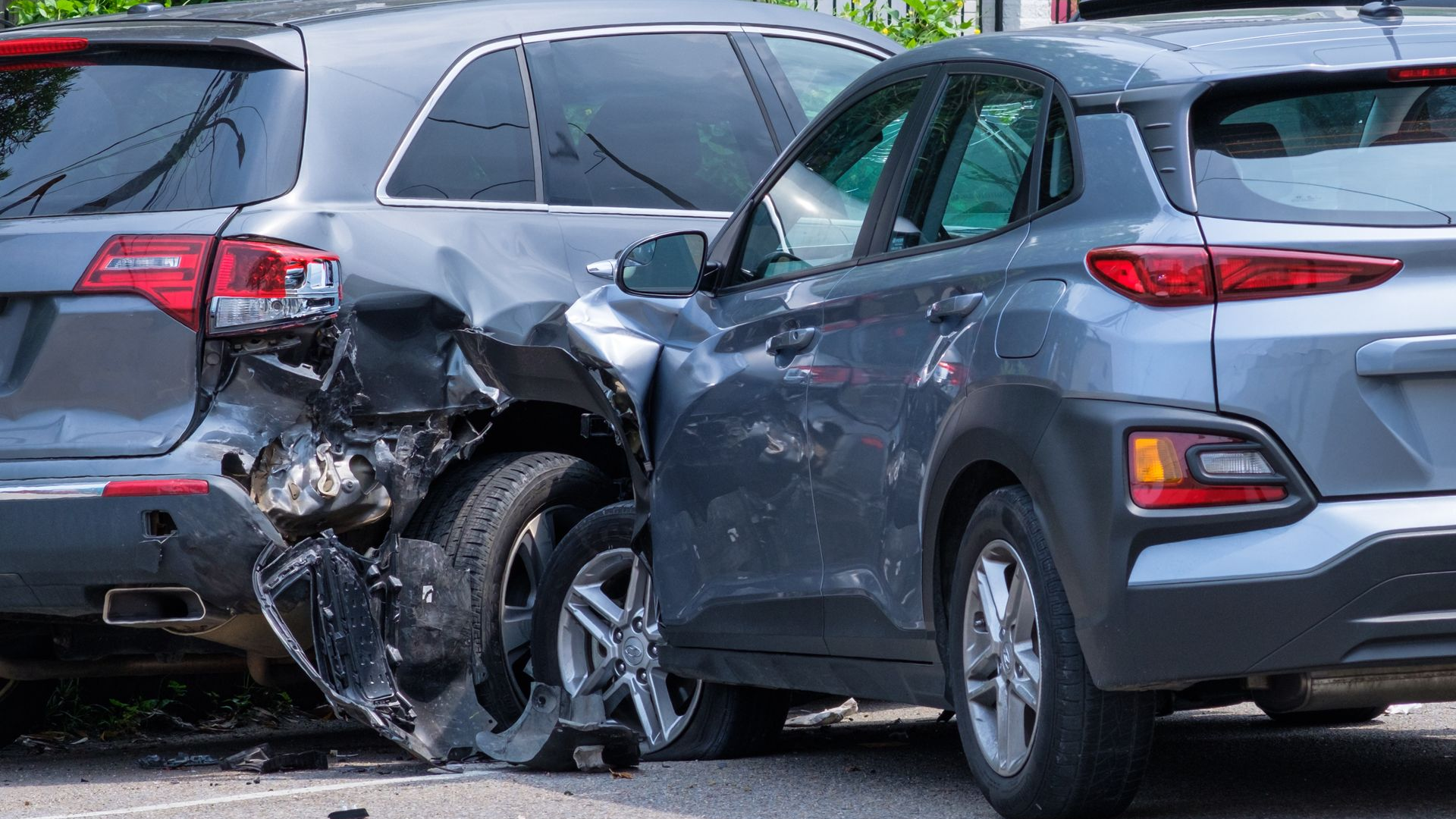 Two gray cars involved in a rear-end collision; significant damage to both vehicles.