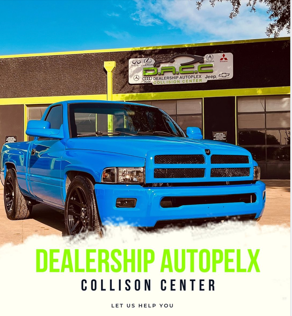 Bright blue Dodge Ram pickup truck in front of a collision center with a green and yellow sign. 