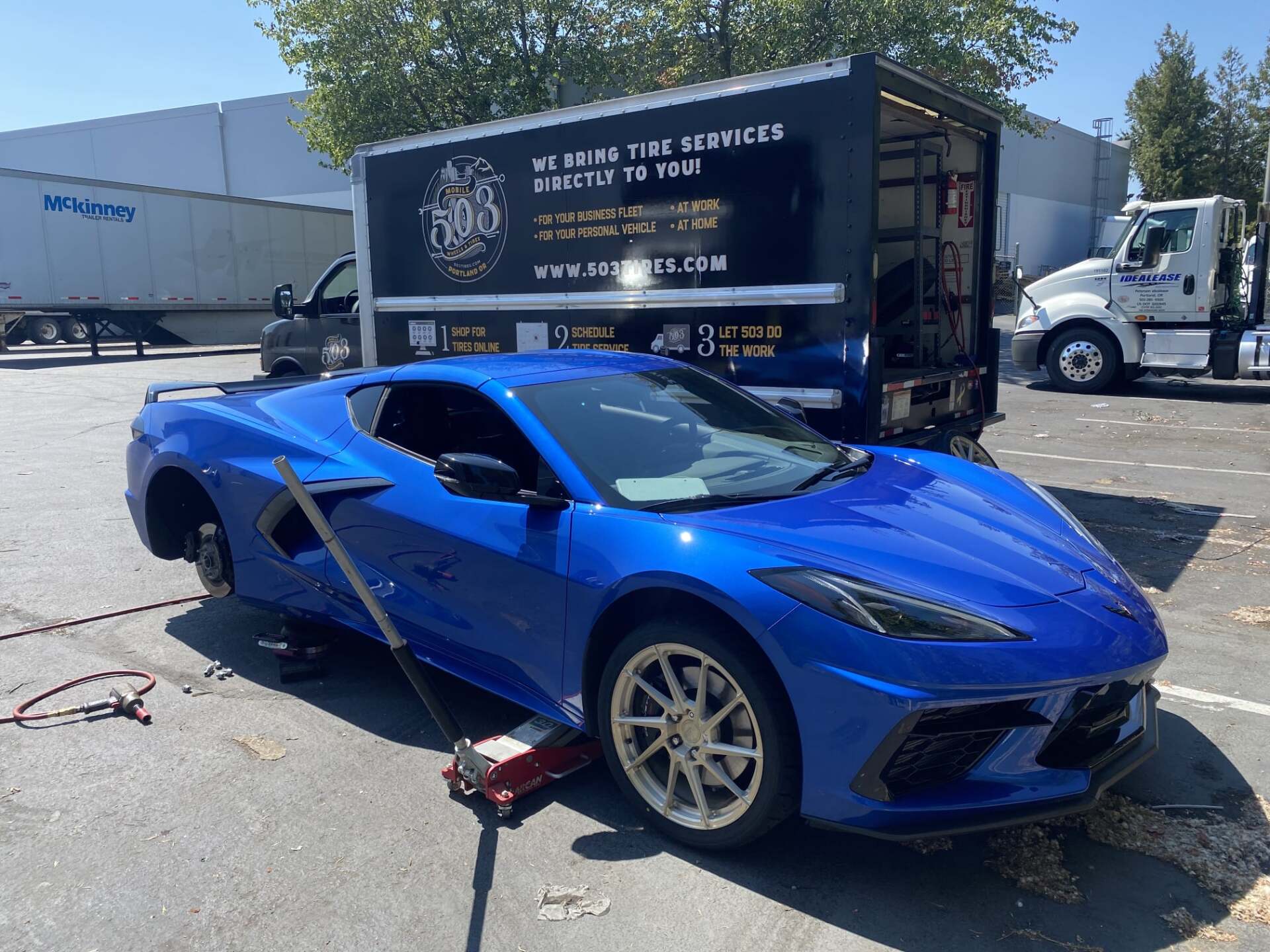 503 Tires mobile tire shop servicing a blue car on the road.