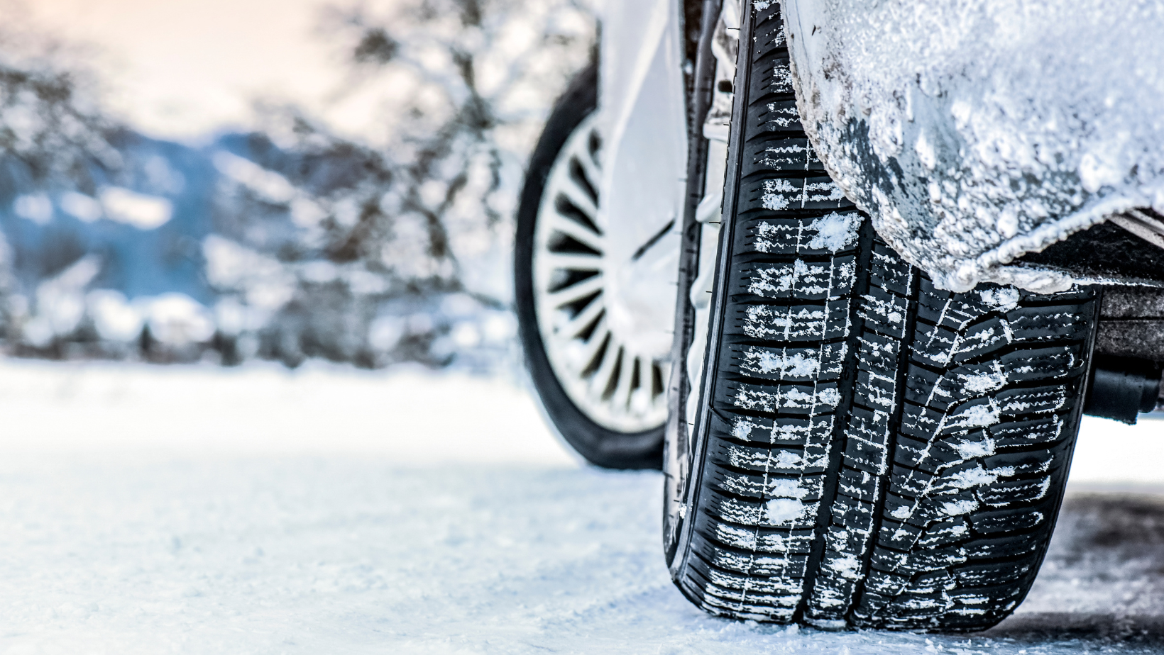 Close up photo of winter tires on a snowy road