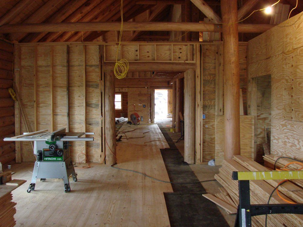 A table saw is sitting in the middle of a wooden room.