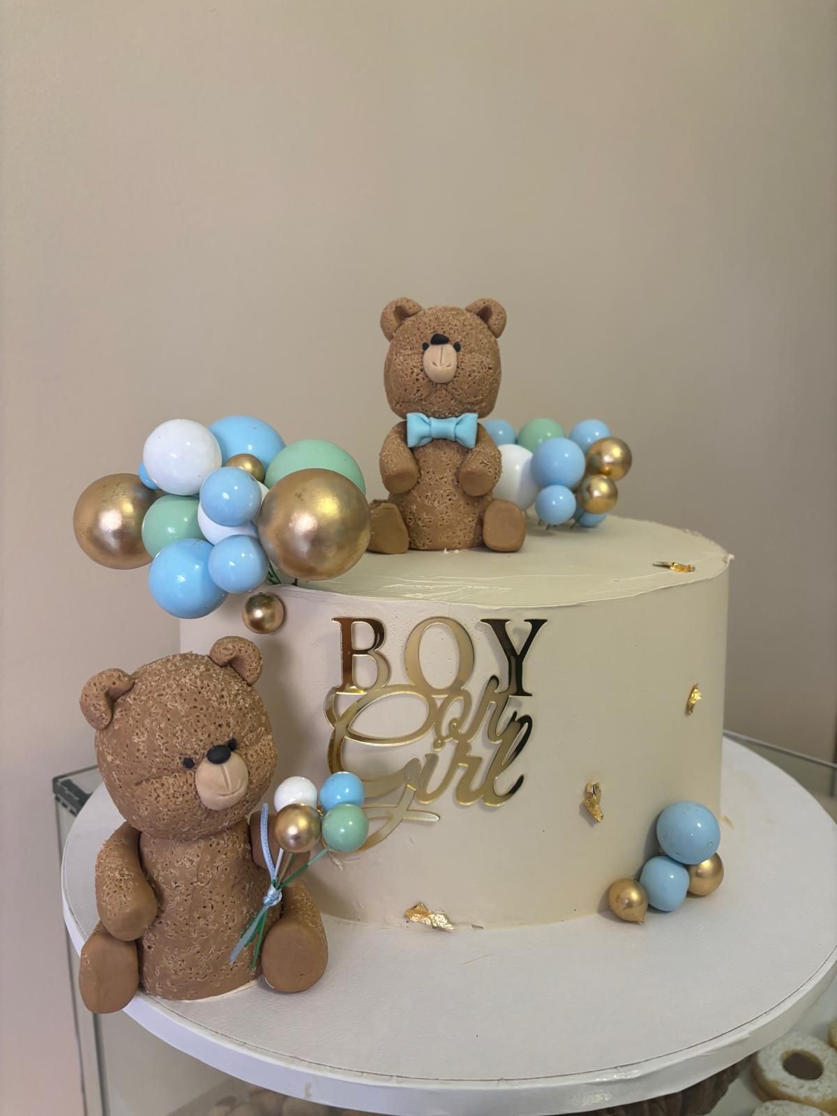 Torta per baby shower con decorazioni a forma di orsetto e palloncini.