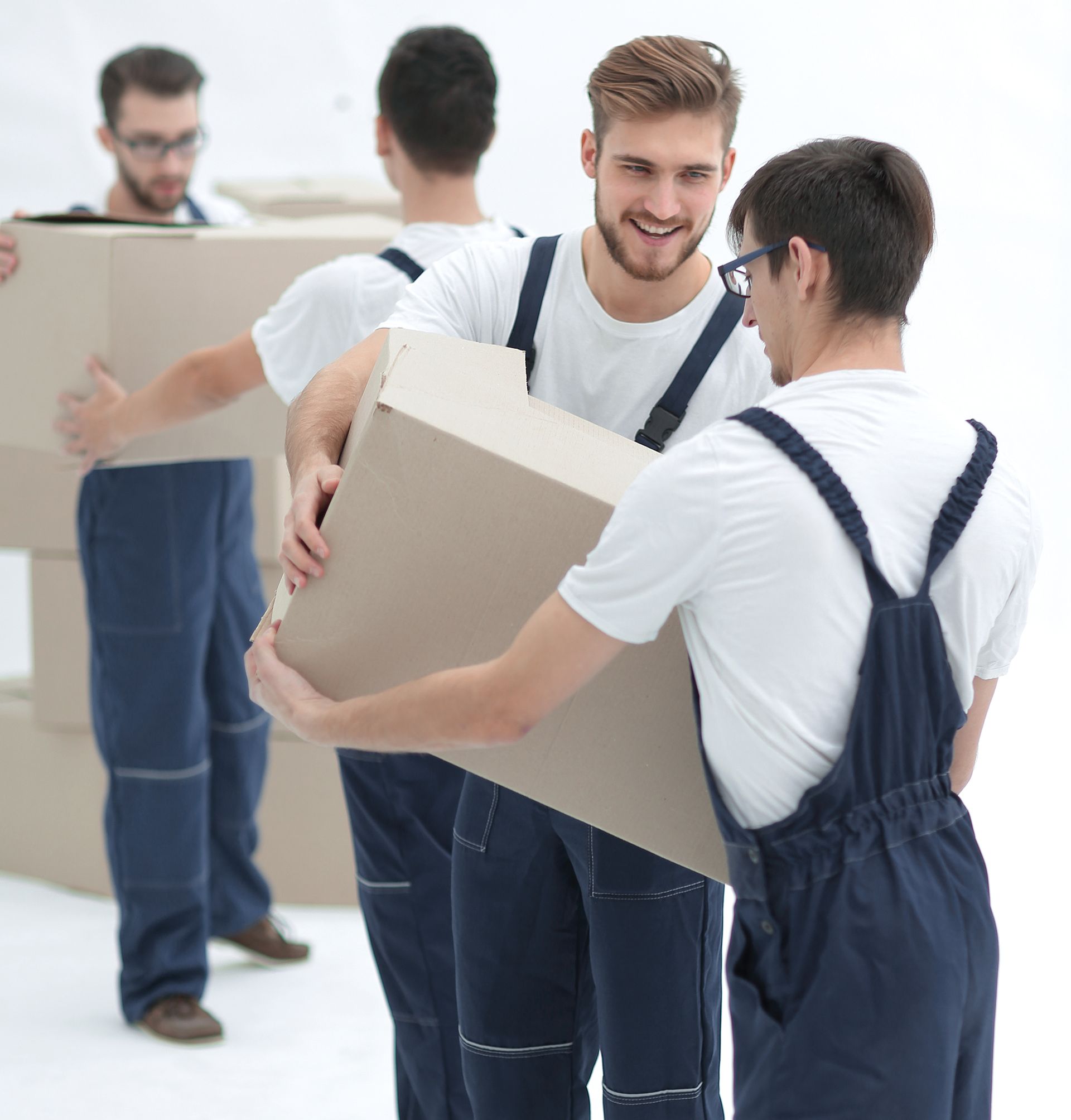 A group of men in overalls are carrying cardboard boxes