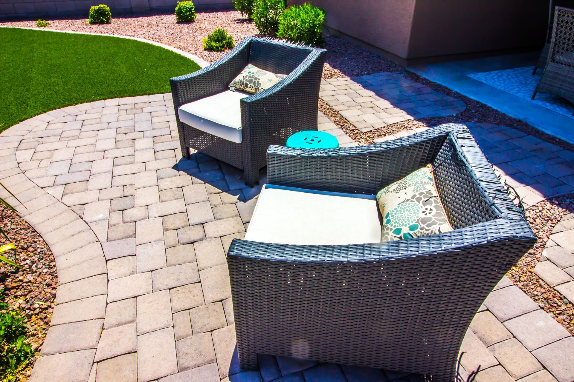 A herringbone pattern of rectangular paving stones in alternating shades of tan, brown, and grey.