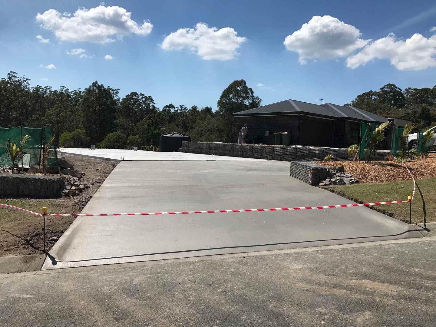 A Concrete Driveway is Being Built in Front of a House — Peter Bishop Concreting In Cooroy, QLD