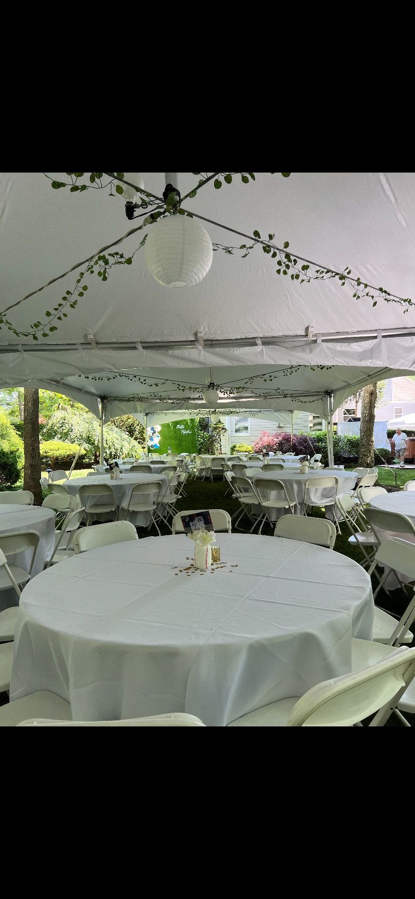 A tent with tables and chairs set up for a wedding reception.