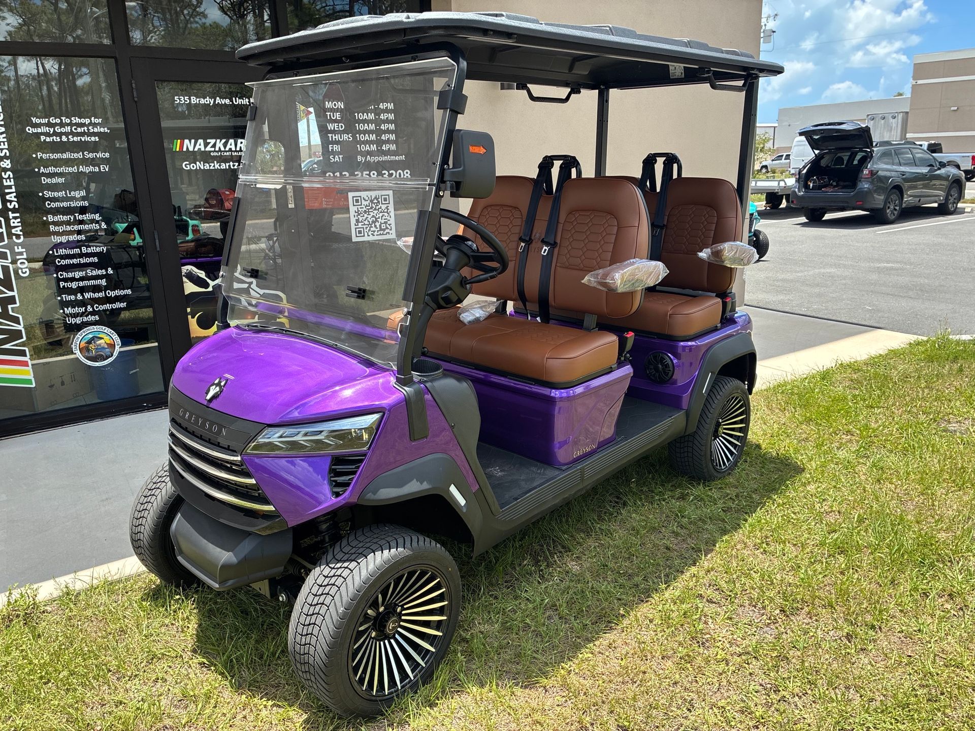 Yellow golf cart with black roof, seats, and wheels, parked indoors.