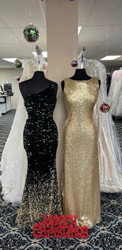 Two dresses , one black and one gold , are on mannequins in a store.