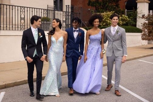 A group of people in prom dresses and suits are walking down a street - Salina, KS - Princess & Penguin Formalwear