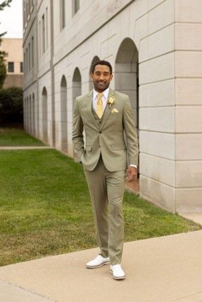 A man in a suit and tie is standing in front of a building - Salina, KS - Princess & Penguin Formalwear
