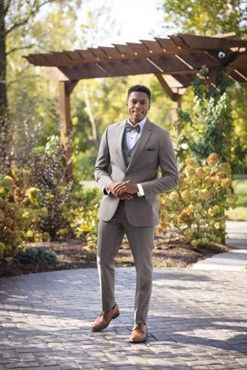A man in a suit and bow tie is standing under a pergola - Salina, KS - Princess & Penguin Formalwear