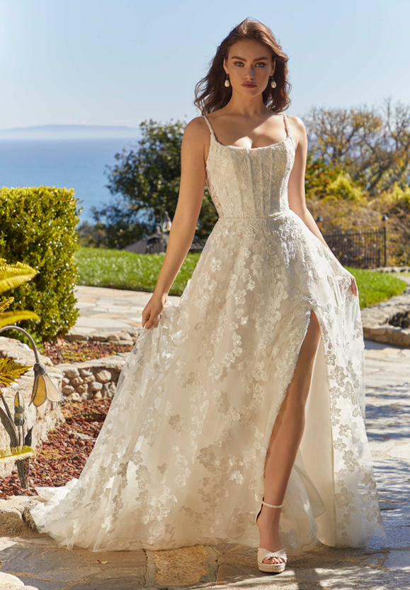 A woman is wearing a white wedding dress with a high slit - Salina, KS - Princess & Penguin Formalwear