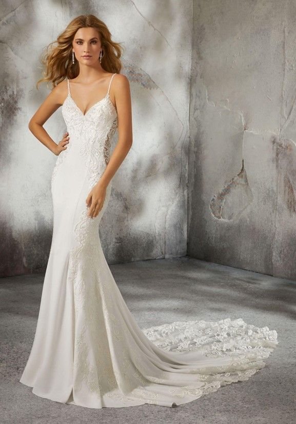 A woman in a white wedding dress is standing in front of a wall - Salina, KS - Princess & Penguin Formalwear