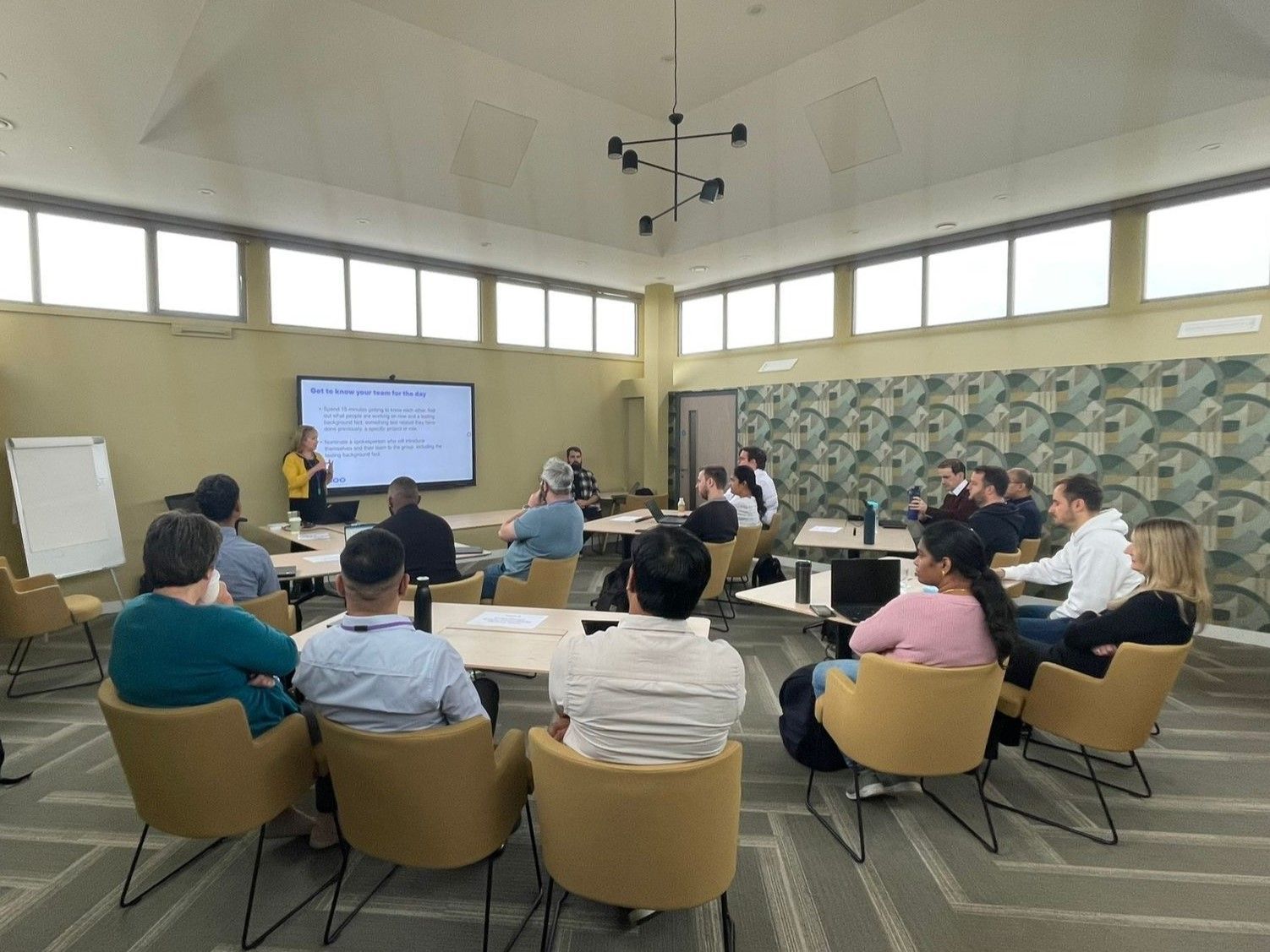 A group of people are sitting at tables in a conference room.
