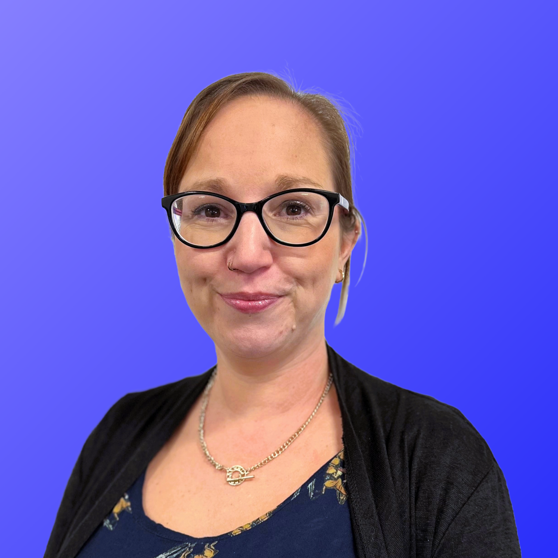 A woman is smiling in front of a blue background.