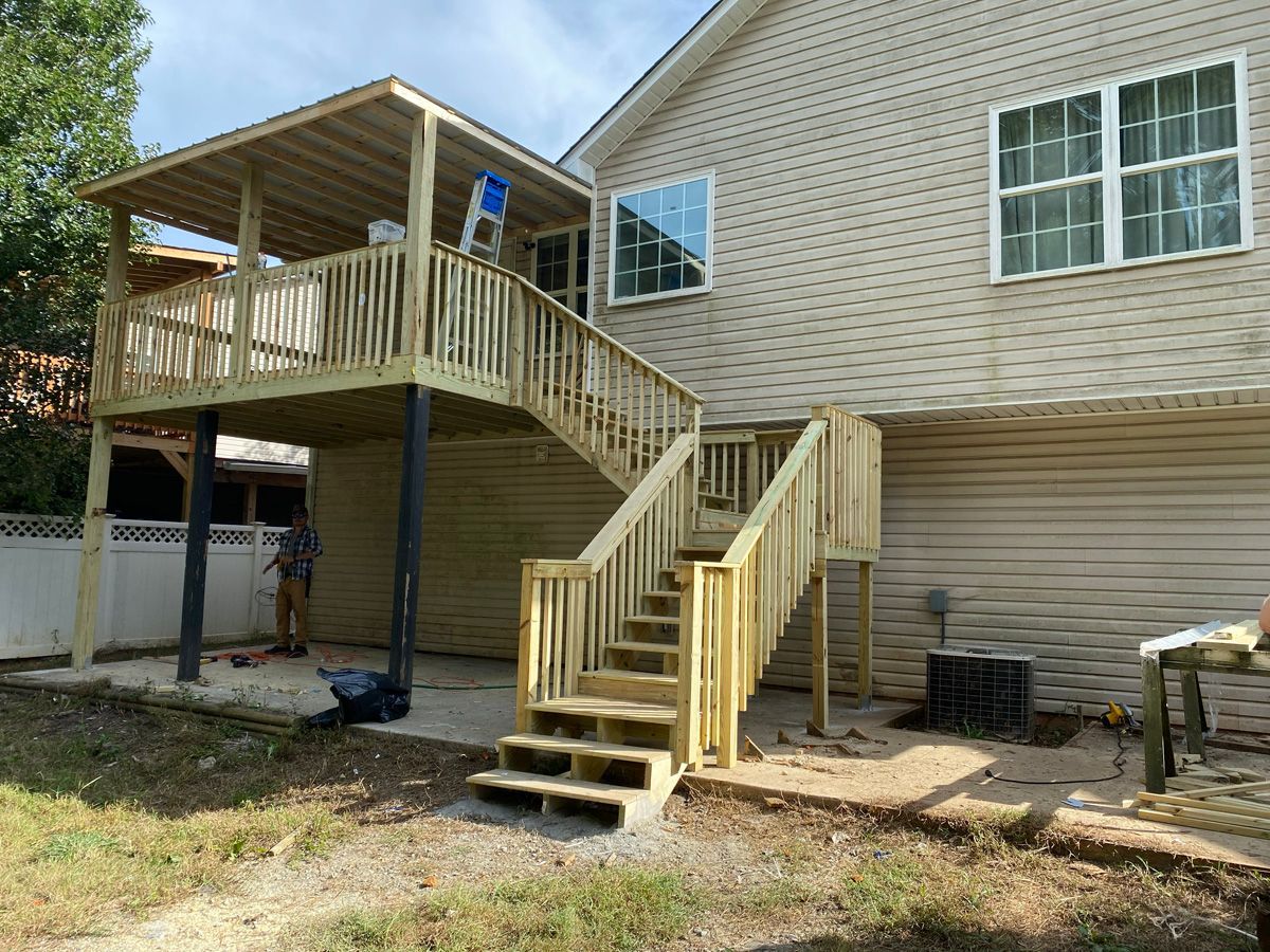 Wooden accessibility ramp and stairs leading to a raised deck on a house exterior