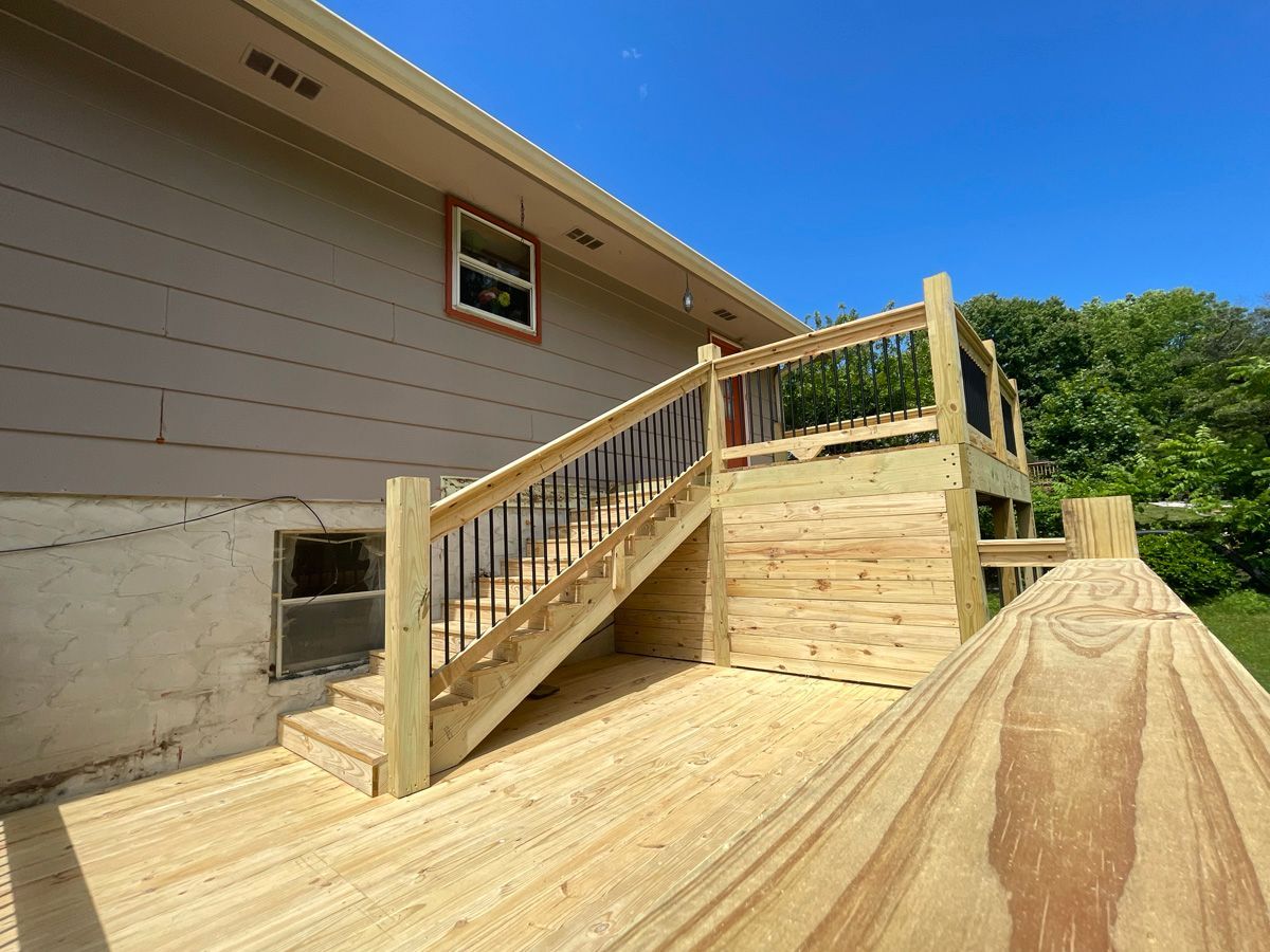Wooden accessibility ramp with handrails leading to a house entrance on a sunny day