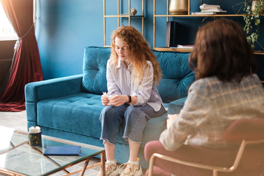 Woman on a Blue Couch Talking to Another Person — AT My Place Counselling and Psychotherapy in Neutral Bay, NSW