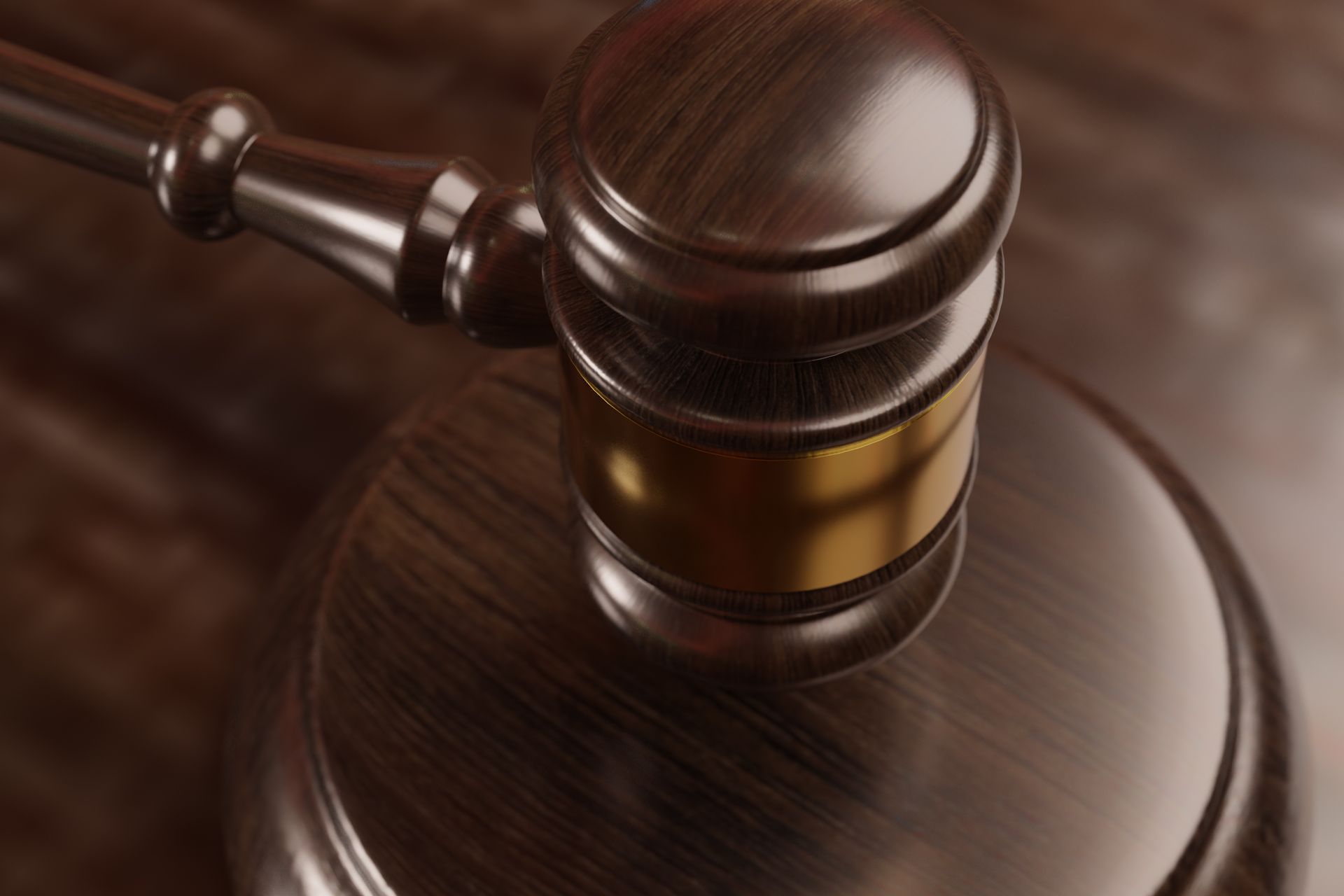 A close up of a wooden judge 's gavel on a wooden table.