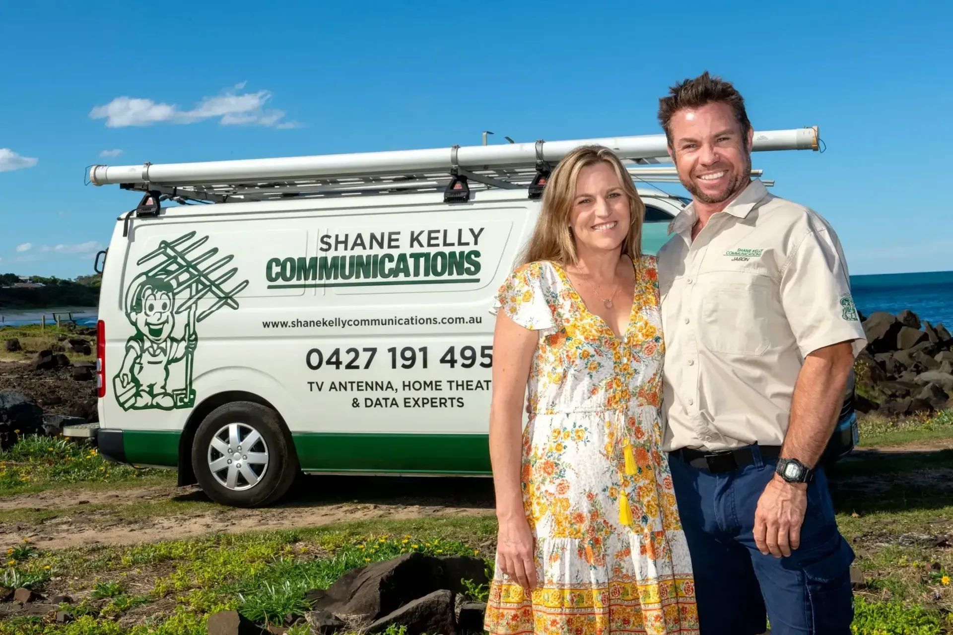 Man and Woman Stand Near a Van With Business Logo — Shane Kelly Communications in Lennox Head, NSW