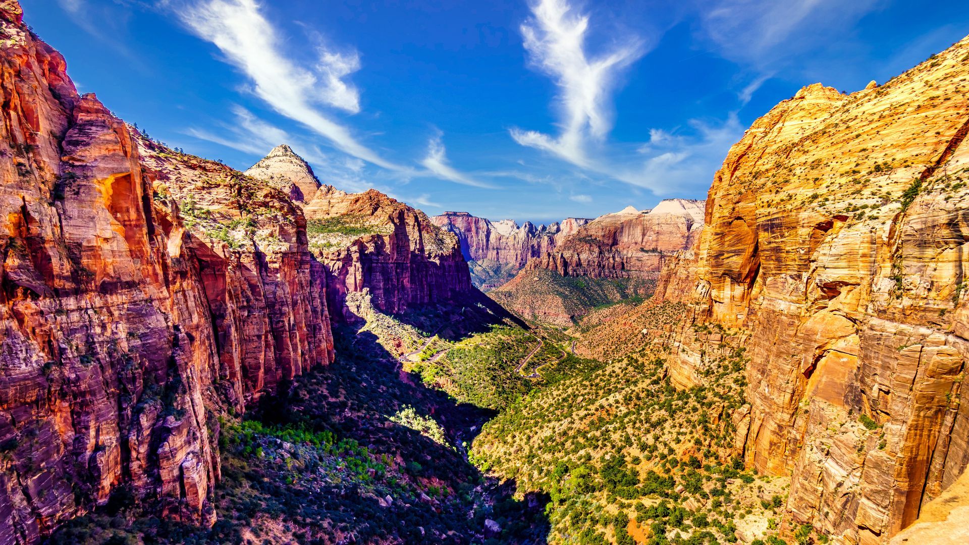 An aerial view of a canyon filled with mountains and trees.