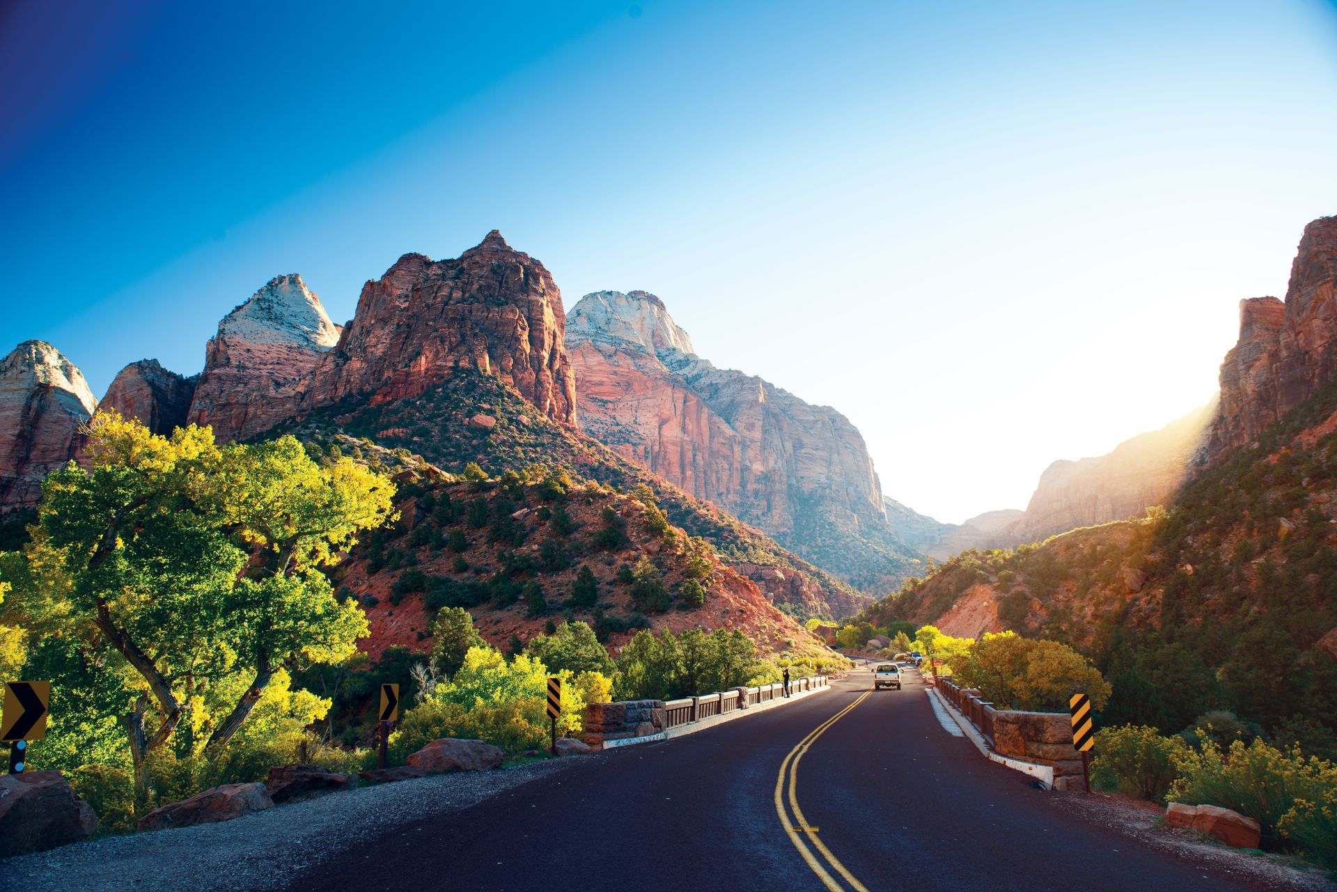 A road going through a valley with mountains in the background.