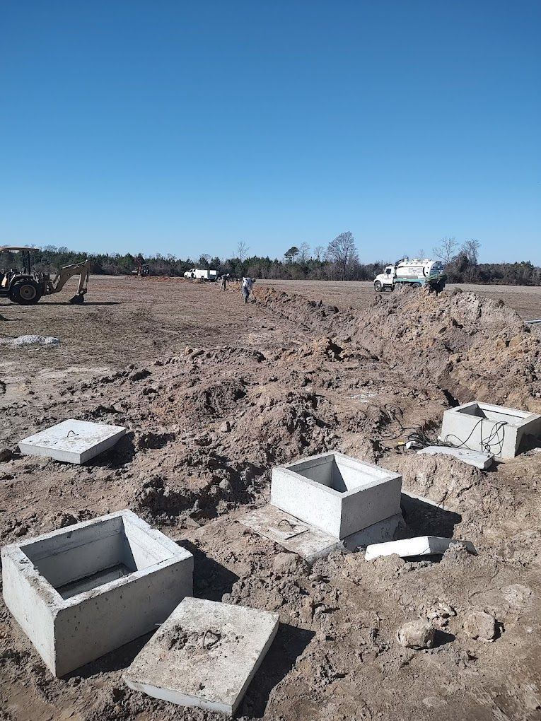 A group of concrete blocks are sitting in the dirt in a field.