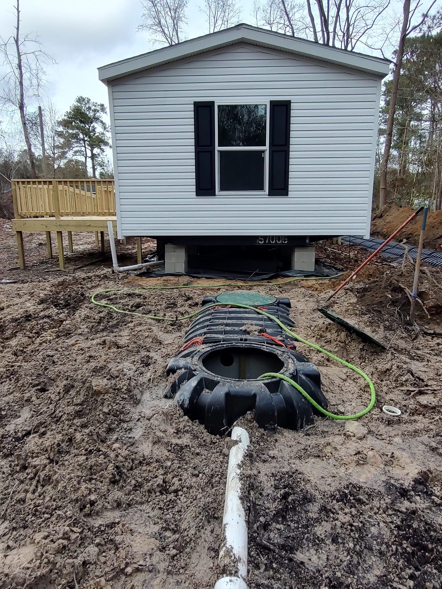 A mobile home is sitting in the middle of a dirt field.