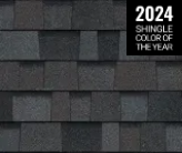 A close-up of charcoal-colored architectural roofing shingles with a label reading