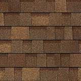 A close-up of brown, rectangular architectural asphalt roof shingles arranged in an overlapping, layered pattern.
