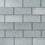 A close-up view of a standard running bond pattern of gray, rectangular, textured concrete pavers or bricks.