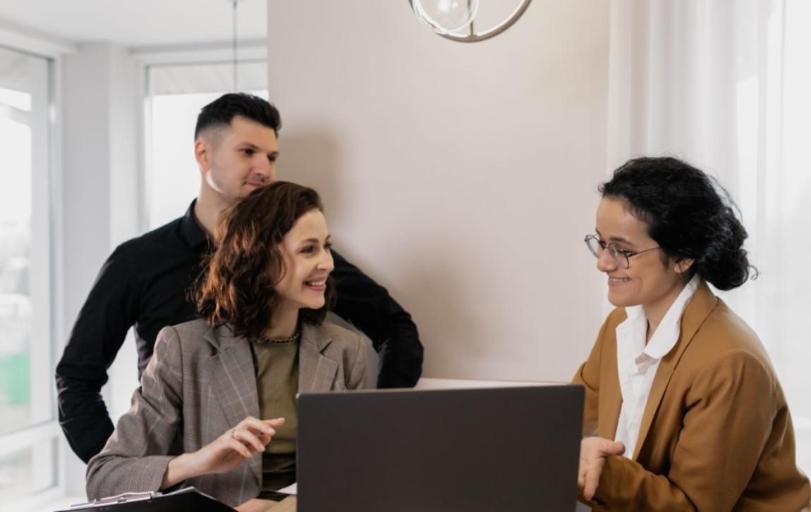 Licensed insurance agent reviewing coverage options with two clients at a laptop